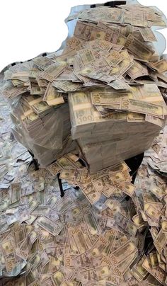 a large pile of money sitting on top of a white table next to a mirror