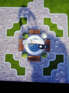 an aerial view of a table and chairs in the middle of a courtyard with green grass