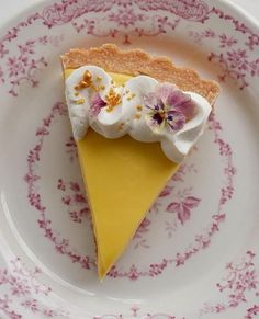 a piece of pie on a pink and white plate with floral designs around the edges