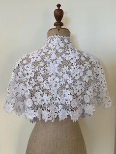 A stunning antique Irish crochet lace capelet made by hand in white cotton. It has a grown on collar and has many beautiful three dimensional florals within the design. This would make an ideal cover up to be worn with a wedding dress or a fabulous large collar over a contrast coloured dress. Length at back including the collar : 15" Length at front edge including the grown on collar : 15 1/2" Top edge of collar : 16" Hem circumference: 84" Good antique condition. Victorian Capelet, White Crochet Lace For Ceremony, 1890s Capelet, White Crochet Lace In Vintage Style, Lace Capelet, Wedding Capelet, White Victorian Crochet Lace, Elegant Vintage White Crochet Lace, Crochet Capelet