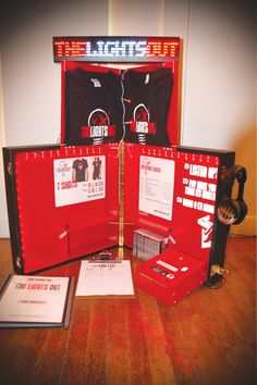 a red and black display case on top of a wooden floor next to other items