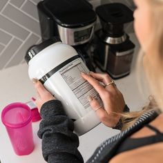 a woman is holding a blender in her hands