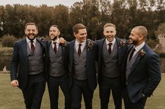 a group of men in suits standing next to each other on a lush green field