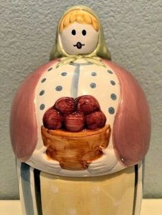 a ceramic figurine with a basket of strawberries