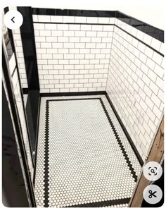 a bathroom with black and white tiles on the floor, and a shower stall door