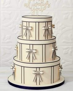 a three tiered cake with bows on the top and congratulations written in white frosting