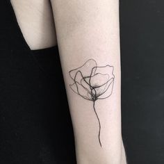 a woman's arm with a single line flower tattoo on the left inner forearm