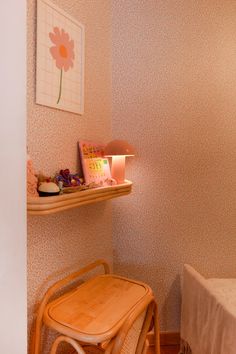 a chair and table in a room with pink wallpaper on the walls behind it