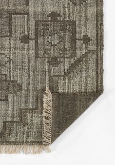 an area rug with fringes on the edges and a square design in grey tones