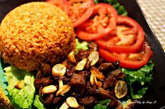 a black plate topped with rice and vegetables