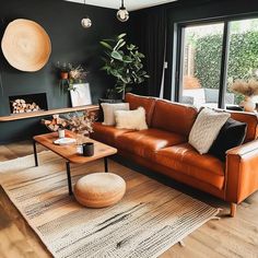 a living room filled with furniture and a large window overlooking the outside area, along with a rug on the floor