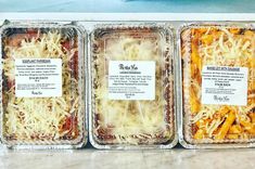 three plastic trays filled with different types of pasta and cheese on top of a counter