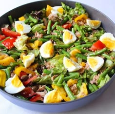 a bowl filled with vegetables and eggs on top of a table