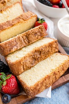 slices of pound cake sitting on top of a cutting board next to berries and yogurt