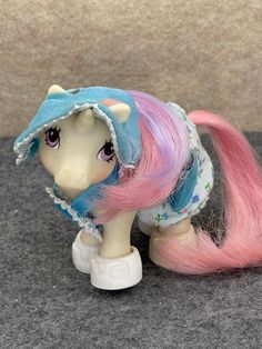 a little pony with pink and blue hair is standing on the floor next to a wall