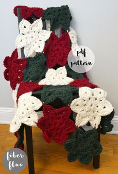 a crocheted chair covered in red, white and green flowers