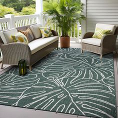 a porch with two chairs and a couch on the floor next to a potted plant