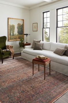 a living room filled with furniture and large windows