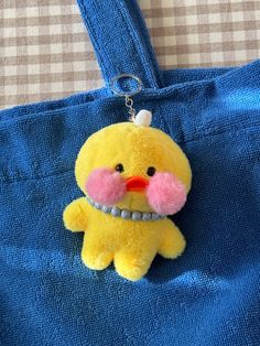 a yellow stuffed animal hanging from a blue bag