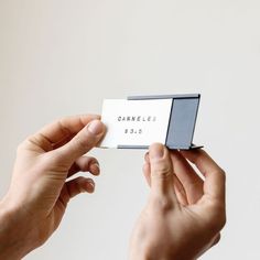 two hands holding up a business card