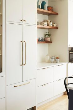 the kitchen is clean and ready to be used for cooking or baking, with white cabinetry and open shelving