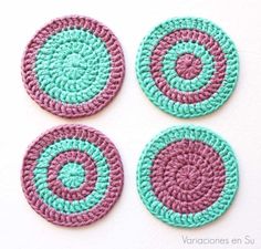 four crocheted coasters are shown on a white surface with green and pink circles