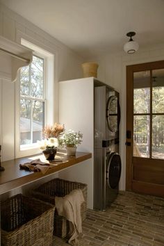 a washer and dryer sitting in a room next to a window with sun coming through