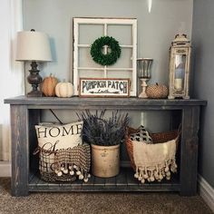 a shelf with some plants and other decorations on top of it in a living room