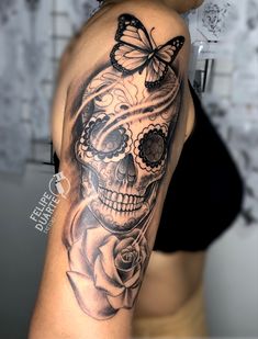 a woman's arm with a skull and butterfly tattoo on the side of her shoulder