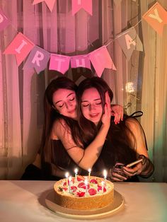 two women hugging each other in front of a birthday cake