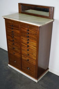 an old wooden dresser with a mirror on it's top and drawers below the drawer