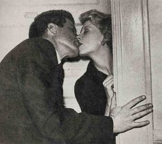 a man and woman kissing each other in front of a door