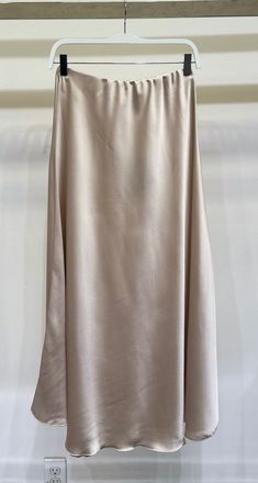 Get ready to pull on this satin maxi skirt and feel like a fashion queen! With its elastic waist for the perfect fit and simple yet stylish design, this skirt is the perfect addition to your wardrobe. Available in a range of colors including beige and champagne, it's the must-have look of the season. Time to step up your fashion game! Satin Maxi Skirt, Fashion Queen, Satin Maxi, New Arrival Dress, British Indian, Mommy And Me, Jacket Tops, Fashion Games, Stylish Design