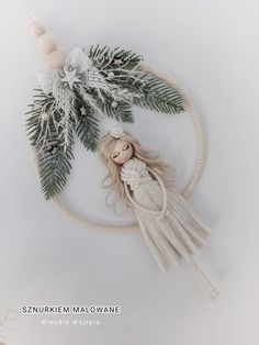 a doll is sitting on top of a rope and surrounded by greenery, beads and candles