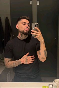 a man taking a selfie in front of a mirror with his hands on his chest