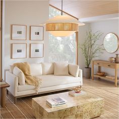 a living room filled with furniture and pictures hanging on the wall above it's coffee table