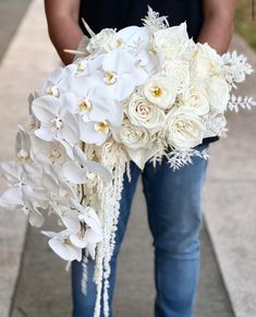 a man holding a bouquet of white flowers