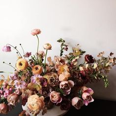 a vase filled with lots of flowers on top of a table