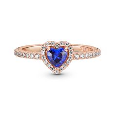 Add a sophisticated edge to your look with the Sparkling Blue Elevated Heart Ring. The ring draws inspiration from the classic Pandora Timeless collection. Hand-finished in 14K rose gold-plating, this piece features a blue heart-shaped central, elevated stone. Clear cubic zirconia create the halo and decorate half of the ring band, with the Pandora logo on the inside of the shank. Stack this ring with hand-finished styles in sterling silver for a statement mixed metal look. Elevated Heart Ring, Pandora Rings Heart, Pandora Logo, Rose Gold Fashion, Diamond Heart Ring, Pandora Rings, Wedding Rings Vintage, Cz Ring, Ring Fit