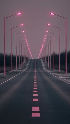 an empty road with pink lights in the middle