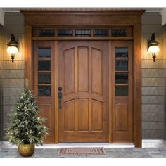 a wooden front door with glass panels