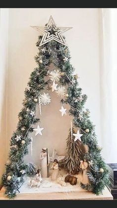 a christmas tree made out of fake snowflakes and other decorations on a mantle