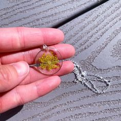 a person holding a tiny yellow flower in their hand