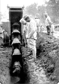 an old black and white photo of men digging in the ground with trenchs behind them