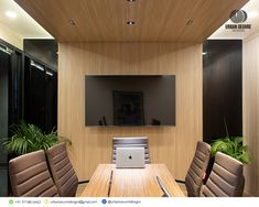 an empty conference room with chairs and a laptop on the table in front of a flat screen tv