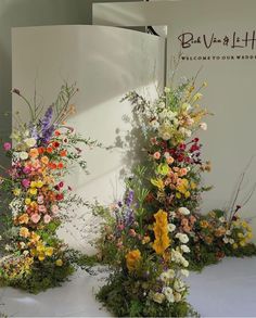 three tall flower arrangements sitting on top of a table