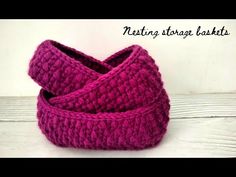 a pink knitted bag sitting on top of a wooden table next to a white wall