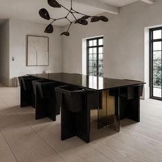 an elegant dining room with black tables and chairs in front of two large windows that look out onto the outdoors