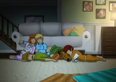 three people laying on the floor in front of a couch