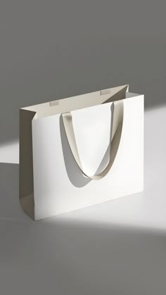 a white paper bag sitting on top of a gray floor next to a black and white wall